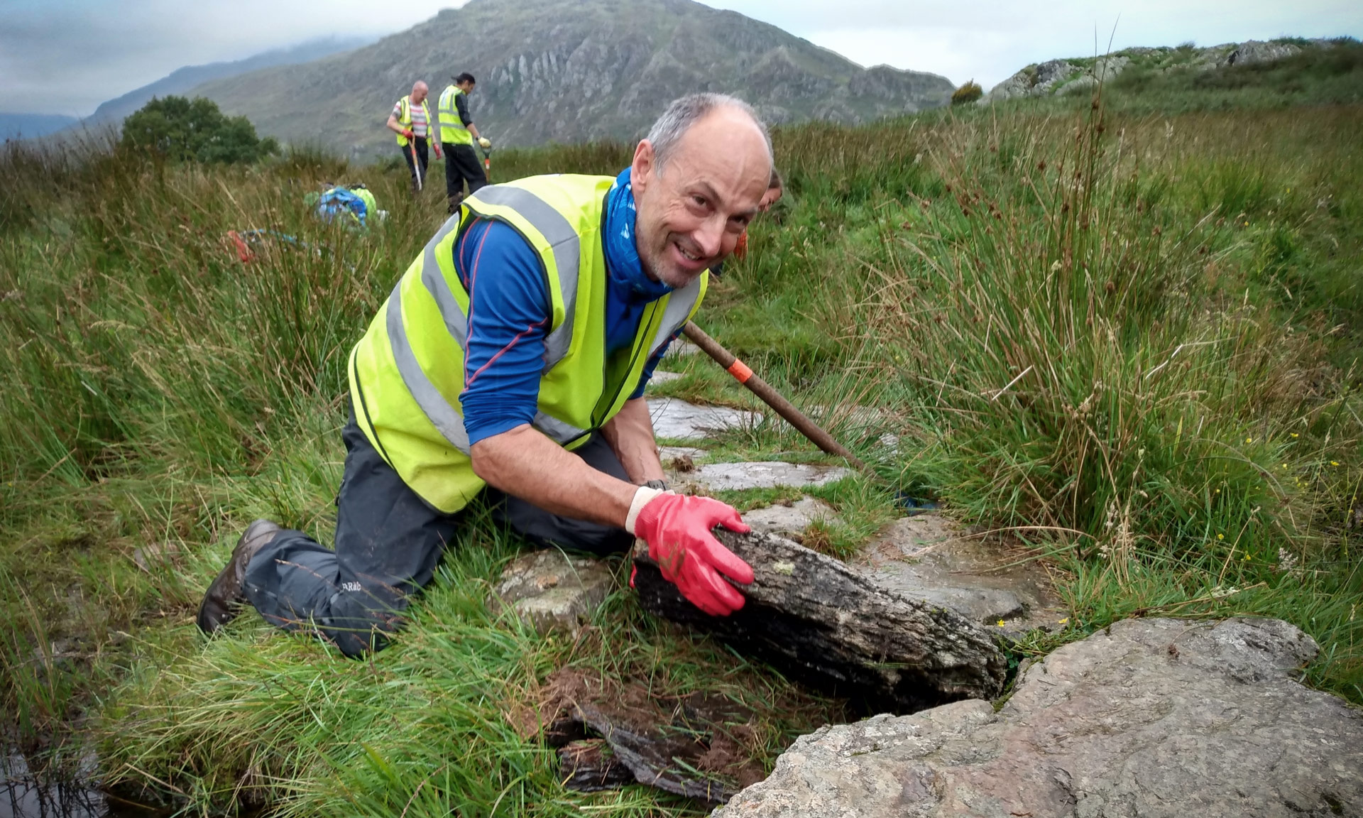 A volunteer works on a stone path in the National Park.